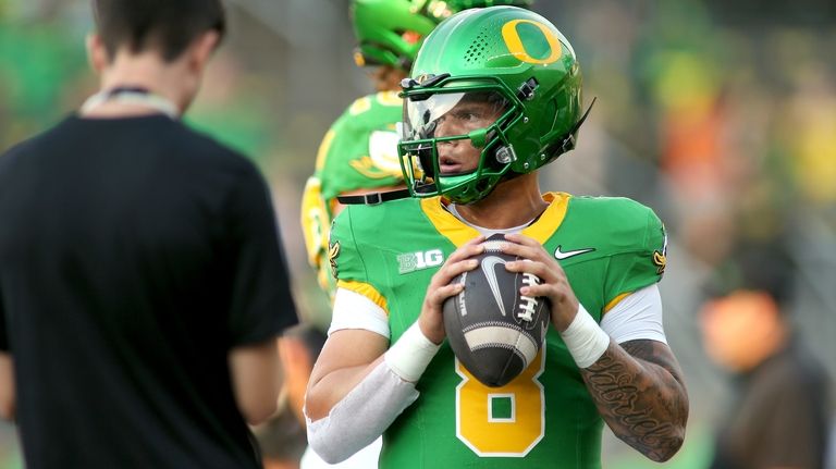 Oregon quarterback Dillon Gabriel warms up before an NCAA college...