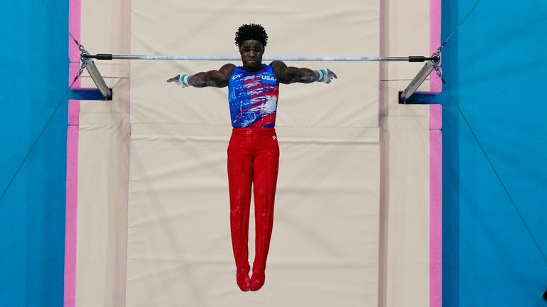 Frederick Richard, of United States, performs on the bars during...