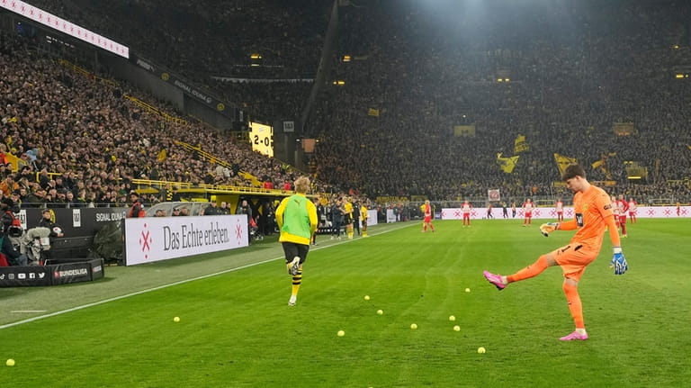 Dortmund's goalkeeper Gregor Kobel kicks tennis balls thrown on the...