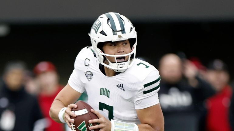 Then-Ohio University quarterback Kurtis Rourke (7) looks to pass the...