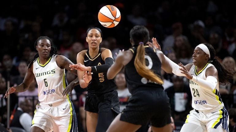 Las Vegas Aces forward A'ja Wilson, center left, passes to...