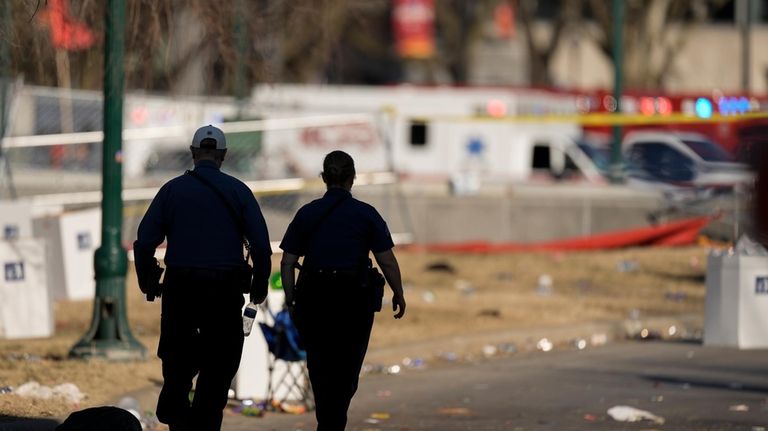 Emergency medical technicians walk around the scene after an incident...