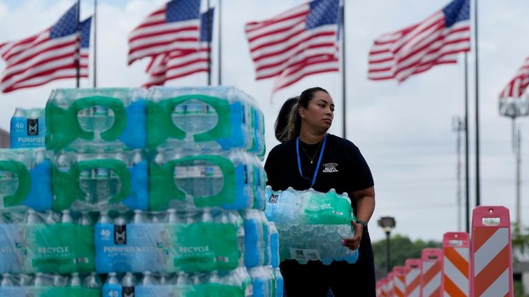 Staff at Lakewood Church hand out water and operate a...