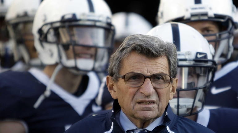 Penn State coach Joe Paterno stands with his players before...