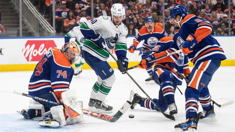 Vancouver Canucks' Elias Pettersson (40) is stopped by Edmonton Oilers...