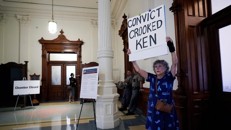 Ellen McCluskey holds a sign outside the Senate Chamber as...