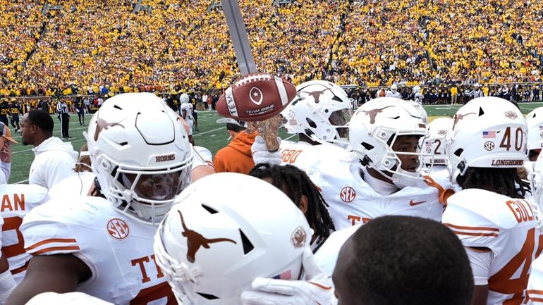 Texas defensive back Andrew Mukuba celebrates his interception with the...