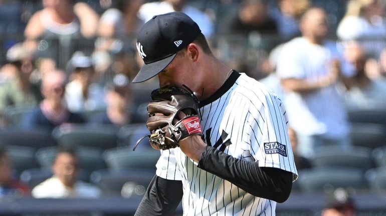 Yankees starting pitcher Will Warren yells into his mitt after...