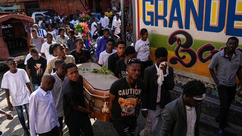 Friends and family accompany the coffin that contain the remains...