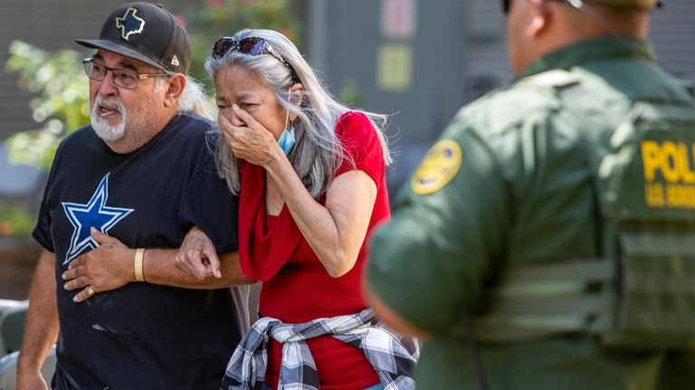 A woman cries as she leaves the Uvalde Civic Center...