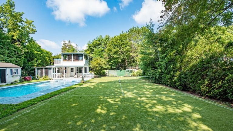 A balcony overlooks the backyard, which features a pool and tennis...