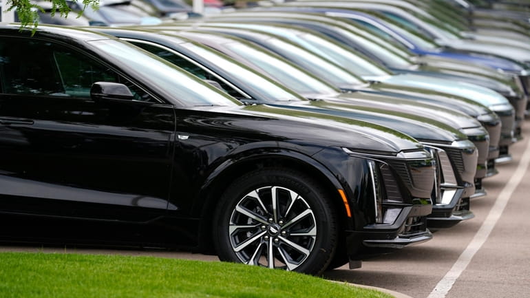 Vehicles sit in a row outside a dealership, June 2,...