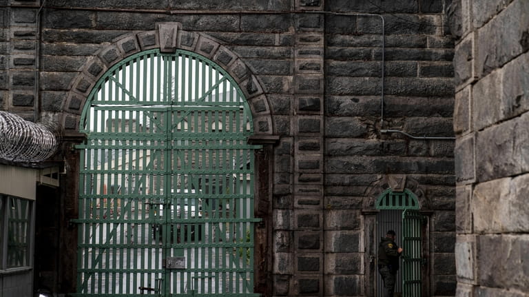 A prison guard walks through a gate at Folsom State...