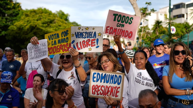 Supporters of Venezuelan opposition presidential candidate Edmundo Gonzlez hold signs...