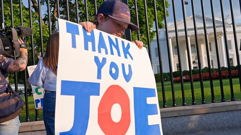 Hugh Kieve, 10, of Washington, holds a sign outside the...