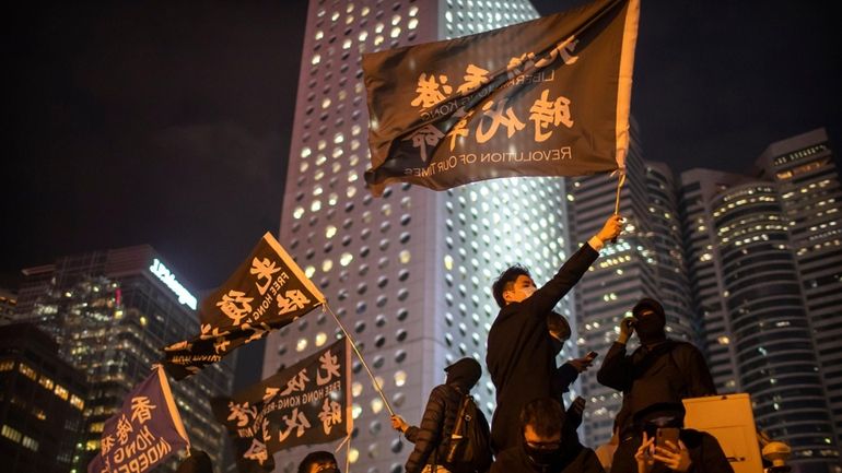 A protestor holds a flag that reads: "Liberate Hong Kong,...