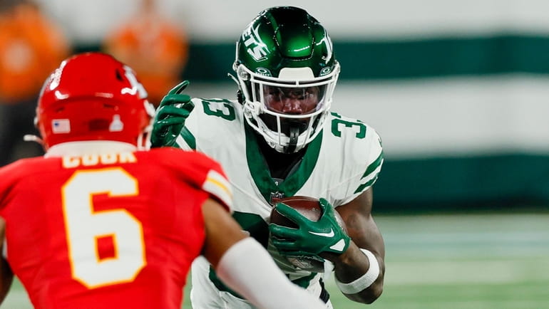 Jets running back Dalvin Cook tries to elude Kansas City safety...