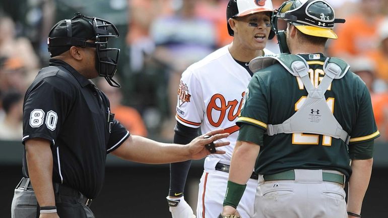 In this Sunday, June 8, 2014 photo, home plate umpire...