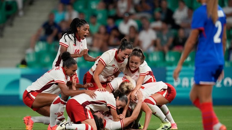 Canada's players celebrate after Vanessa Gille scored her side's second...