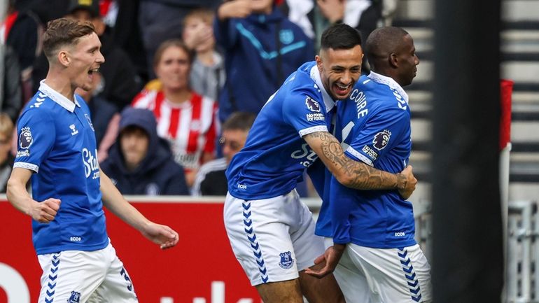 Everton's Abdoulaye Doucoure, right, celebrates after scoring the opening goal...