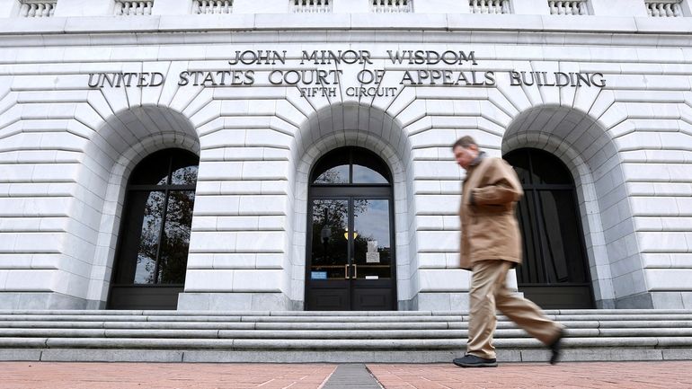 A man walks in front of the 5th U.S. Circuit...