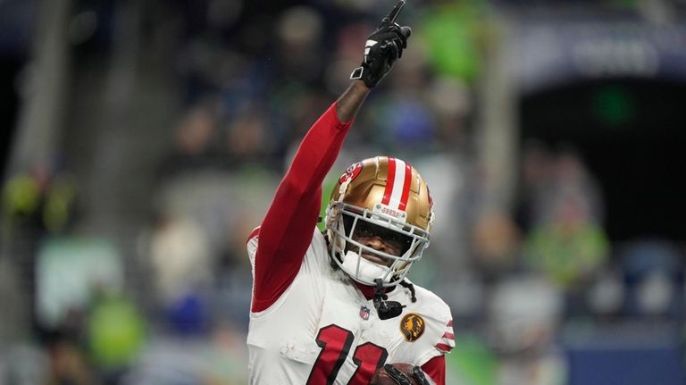 San Francisco 49ers wide receiver Brandon Aiyuk runs back to...