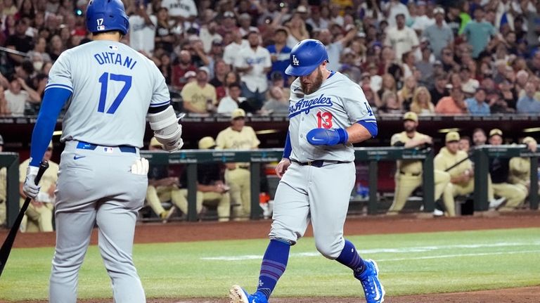 Los Angeles Dodgers' Max Muncy (13) scores a run on...