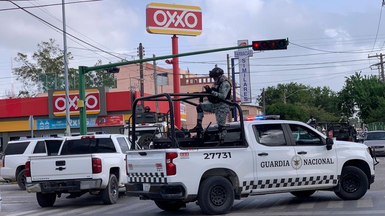 Officers of Mexican National Guard stand on guard near to...