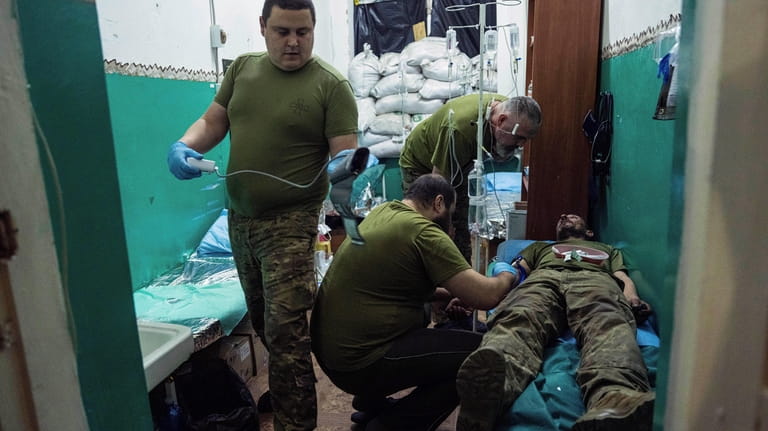 Ukrainian military medics treat a soldier with concussion in a...