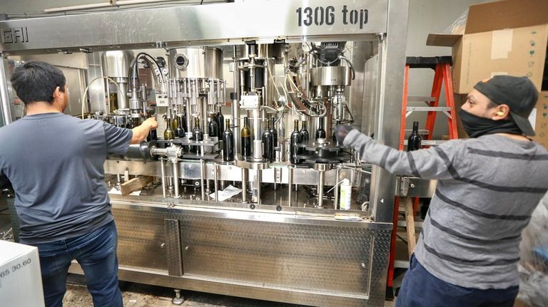 Workers operate the bottling machine at Paumanok Vineyards in Aquebogue....