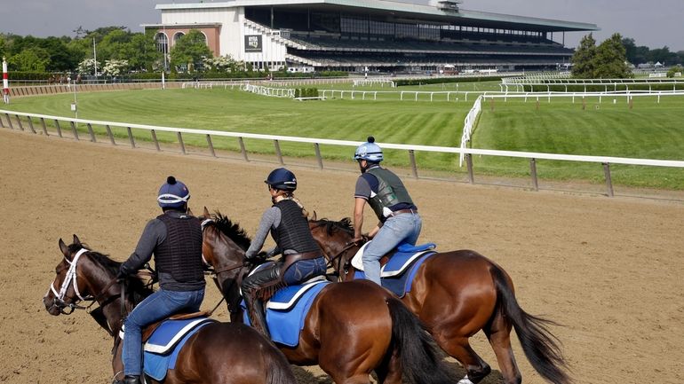 Riders workout with horses at Belmont Park in Elmont, N.Y.,...