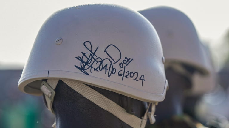 A Kenyan police officer's helmet carries a signature and date...