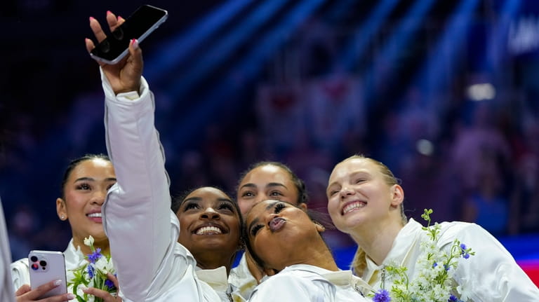 Simone Biles takes a selfie with Suni Lee, left, Hezly...