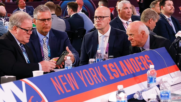The Islanders' table discusses their next pick during the 2024 NHL...