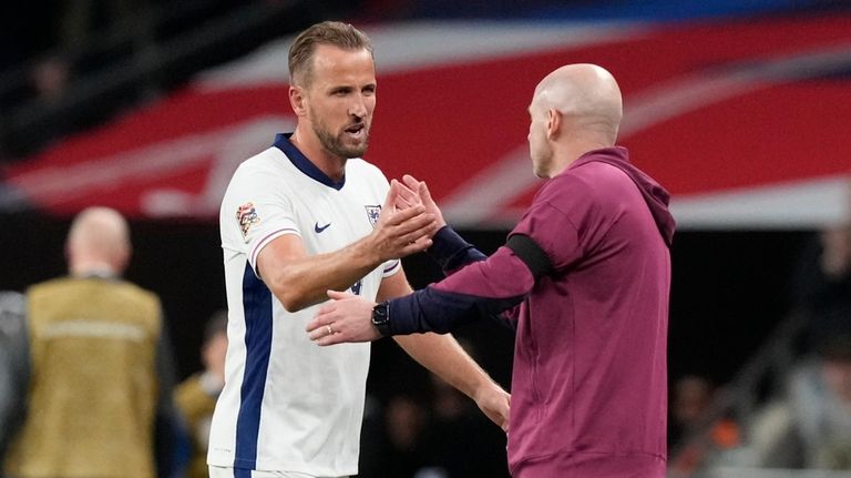 England's Harry Kane, left, is congratulated by England interim manager...