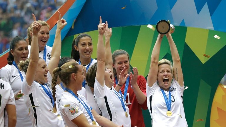 United States' Megan Rapinoe, right, holds up the trophy as...