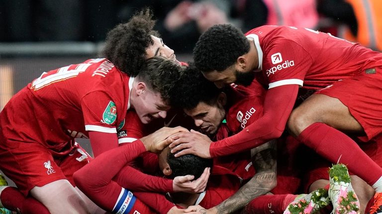 Liverpool's Virgil van Dijk celebrates, surrounded by team mates, after...