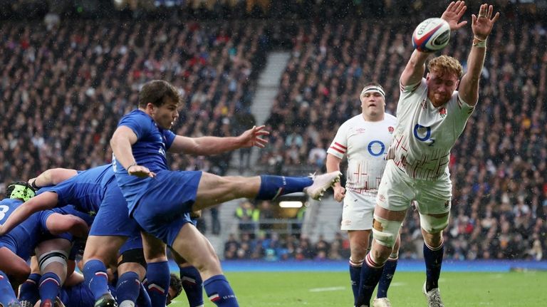 France's captain Antoine Dupont, left, kicks the ball away during...