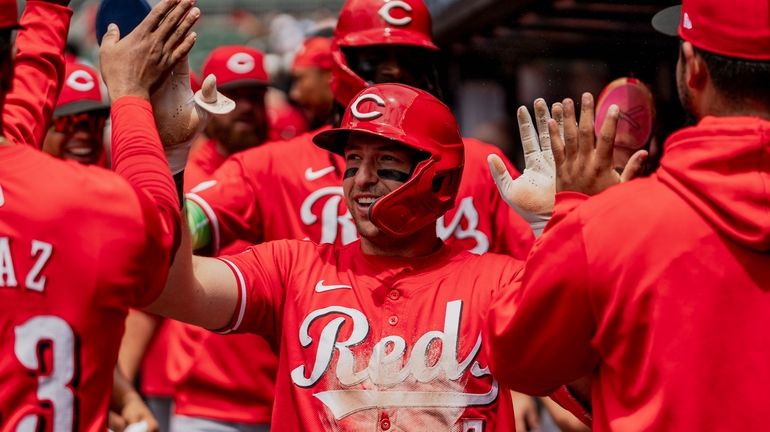 Cincinnati Reds outfielder Spencer Steer (7) celebrates in the dugout...