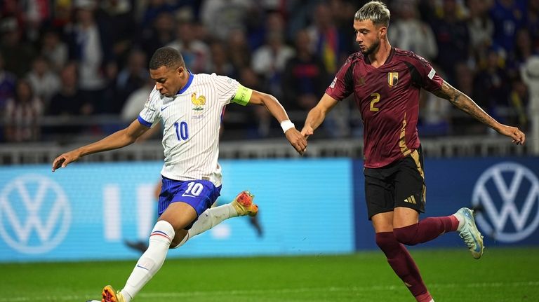 France's Kylian Mbappe, left, controls the ball as Belgium's Zeno...