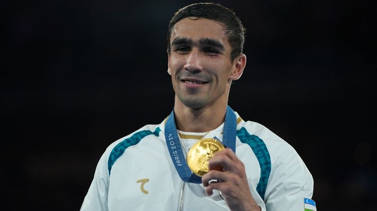 Gold medalist Uzbekistan's Abdumalik Khalokov poses during a medals ceremony...