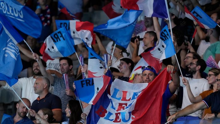 France fans wave their national flags prior to a men's...