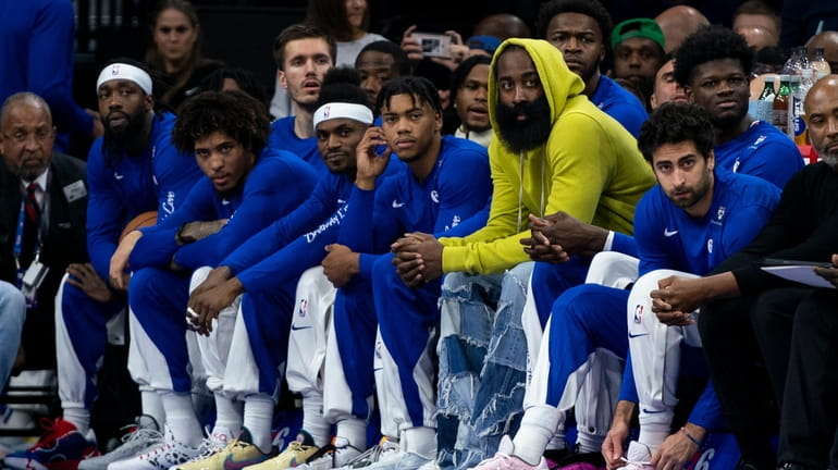 Philadelphia 76ers' James Harden, third from right, looks on from...