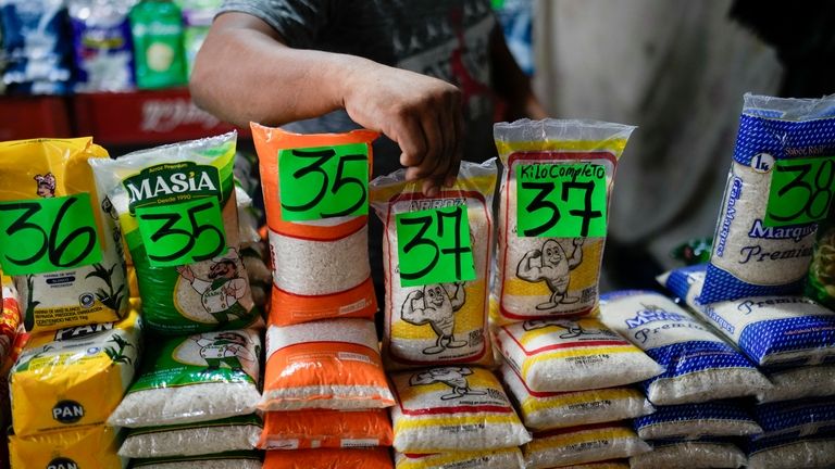 A vendor displays rice at a flea market in Maracaibo,...