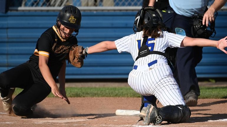 Juli Murillo #23 of St. Anthony's, left, evades the tag...