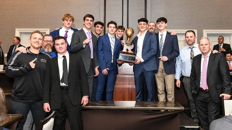 The Sayville football team receives the Rutgers Trophy during the...