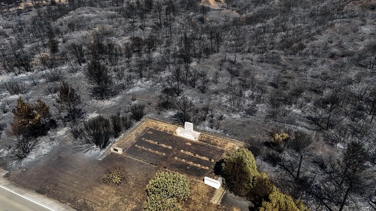 An aerial shot shows part of the extinguished wildfire area...