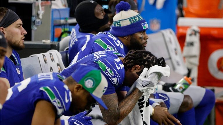 Seattle Seahawks' Jaxon Smith-Njigba (11) and teammates sit on the...