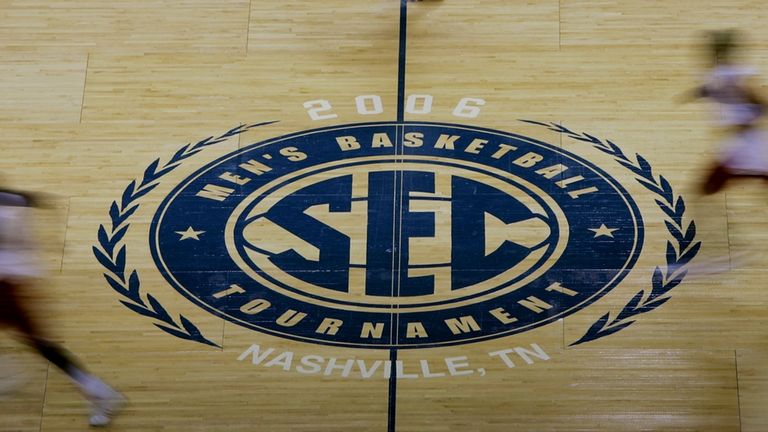 Arkansas players run past the Southeastern Conference logo during practice...