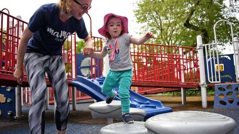 Nina Chalson, 23 months, of Sea Cliff, climbs through the...